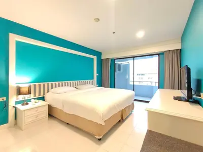 a bedroom with a large bed and a blue wall at Ebina House - SHA Extra Plus in Bangkok