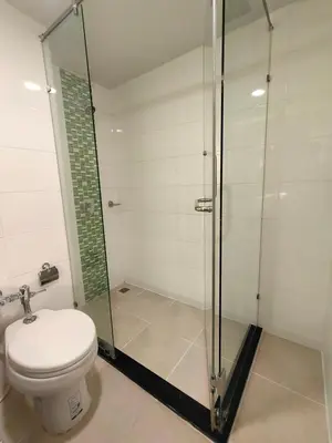 a bathroom with a toilet and a glass shower at Ebina House - SHA Extra Plus in Bangkok