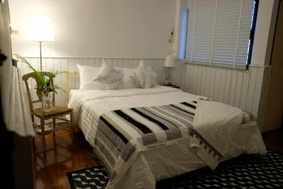 a bedroom with a bed with a striped blanket at TANA CASA 12 Large Sathorn 6BR Townhome with Parking in Bangkok