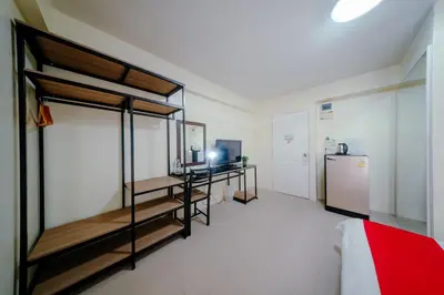 a room with two bunk beds and a refrigerator at Salin Home Hotel Ramkhamhaeng in Bangkok