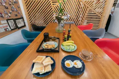 a table with eggs and bread and bottles of beer at Timber Hostel in Bangkok
