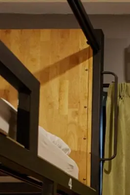 a glass door of a room with a bed at Timber Hostel in Bangkok