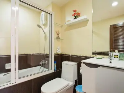 a bathroom with a toilet and a shower and a sink at Serena Sathorn Suites in Bangkok