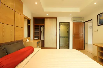 a bedroom with a bed with a red blanket on it at Serena Sathorn Suites in Bangkok