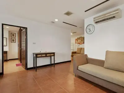 a living room with a couch and a table at Serena Sathorn Suites in Bangkok