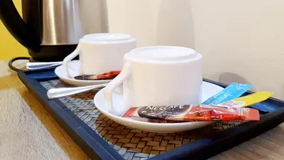 a tray with two cups and toothbrushes on a table at Happio Near Chabad House in Bangkok