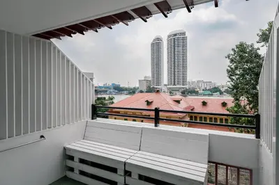 a balcony with a bench and a view of a city at Happio Near Chabad House in Bangkok