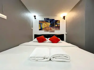a white bed with two towels on top of it at Happio Near Chabad House in Bangkok