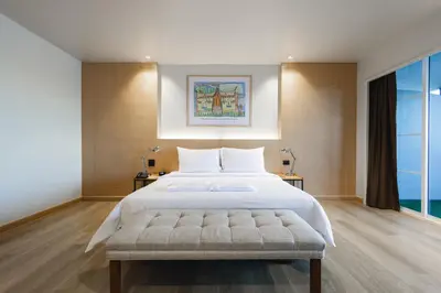 a bedroom with a large bed and a large window at The Royal River Hotel in Bangkok