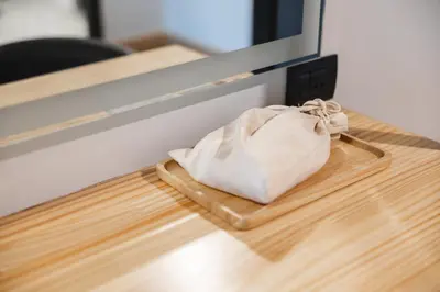a white purse sitting on a table next to a counter at The Royal River Hotel in Bangkok