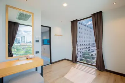 a room with a desk and a large window at The Royal River Hotel in Bangkok