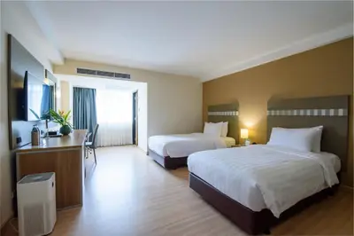 a hotel room with two beds and a television at SC Park Hotel in Bangkok