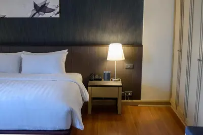 a bedroom with a bed and a table with a lamp at SC Park Hotel in Bangkok