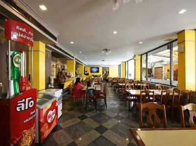 a dining room with tables and chairs in a restaurant at Malaysia Hotel Bangkok in Bangkok