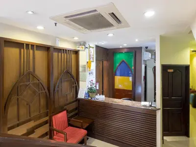 a restaurant with a bar with a red chair at Royal Express Inn in Bangkok