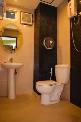 a bathroom with a toilet and a sink and a mirror at Royal Express Inn in Bangkok