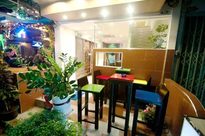 a restaurant with two tables and chairs and a plant at Royal Express Inn in Bangkok