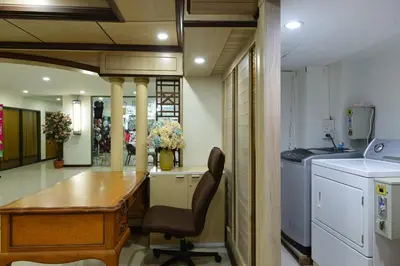 a kitchen with a desk and a table in a room at Nice Palace Hotel in Bangkok