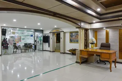 a lobby with a desk and chairs in a store at Nice Palace Hotel in Bangkok