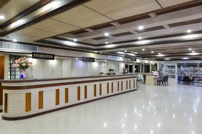 a lobby with a reception counter in a shopping mall at Nice Palace Hotel in Bangkok