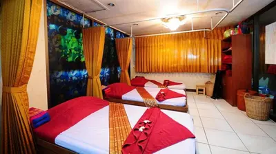 a group of three beds in a room at Nice Palace Hotel in Bangkok