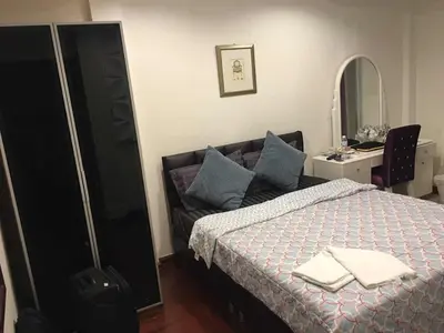 a bedroom with a bed and a mirror at Nineplace 46 in Bangkok
