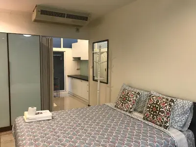 a bedroom with a bed and a living room at Nineplace 46 in Bangkok
