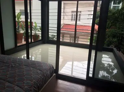 a bedroom with a view of a room with windows at Nineplace 46 in Bangkok