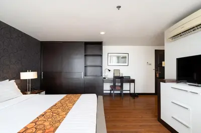 a hotel room with a bed and a desk at Lily Hotel Bangkok in Bangkok