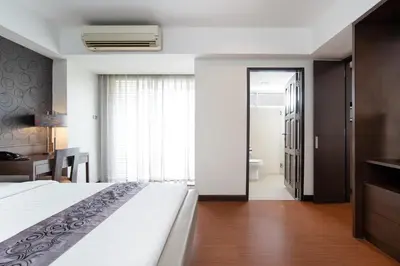 a hotel room with a bed and a bathroom at Lily Hotel Bangkok in Bangkok