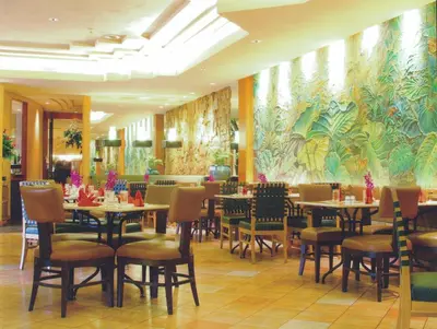 a dining room with tables and chairs and a mural at Indra Regent Hotel in Bangkok