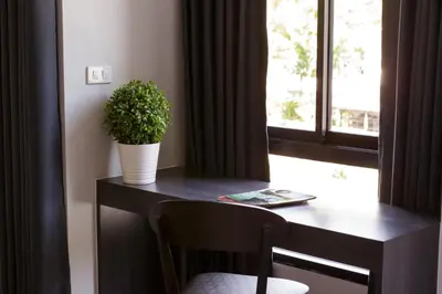 a desk with a potted plant on it next to a window at @S115 Residence in Samutprakarn