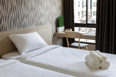 a hotel room with two beds and a desk at @S115 Residence in Samutprakarn