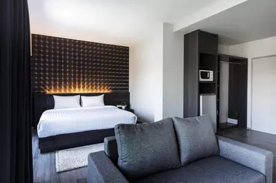 a bedroom with a bed and a couch at @S115 Residence in Samutprakarn