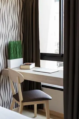 a desk with a chair next to a window at @S115 Residence in Samutprakarn
