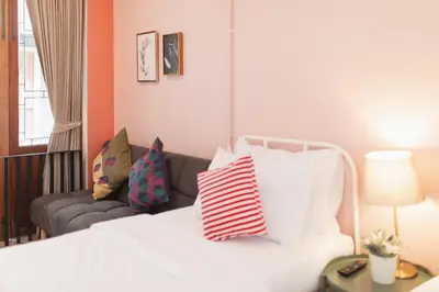 a living room with a white bed and a couch at House Of PaPa Bangkok Siam in Bangkok
