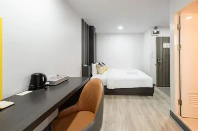 a bedroom with a bed and a desk and a chair at Riski Residence Bangbuathong in Nonthaburi