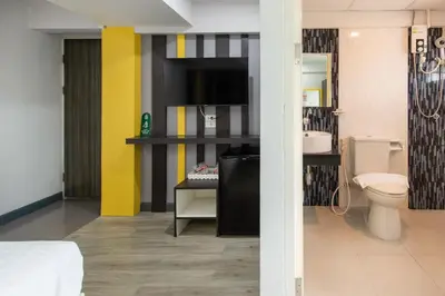 a bathroom with a toilet and a tv in it at Riski Residence Bangbuathong in Nonthaburi