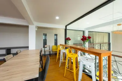 a dining room with a long table and yellow chairs at Riski Residence Bangbuathong in Nonthaburi