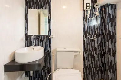 a bathroom with a sink and a toilet and a mirror at Riski Residence Bangbuathong in Nonthaburi
