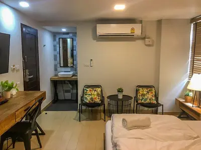 a room with a bed and chairs and a table at Bangkok Saran Poshtel in Bangkok