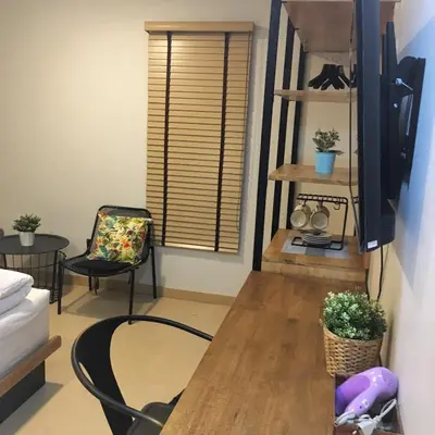 a living room with a table and a chair at Bangkok Saran Poshtel in Bangkok