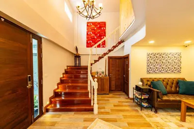 a living room with a staircase and a couch at Maneeya Park Residence in Bangkok
