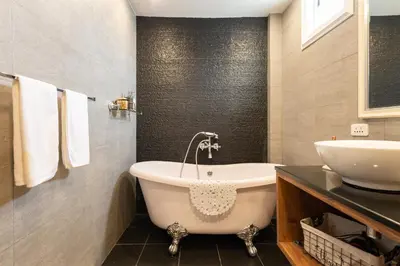 a bathroom with a tub and a sink at Maneeya Park Residence in Bangkok