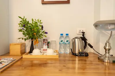 a counter with bottles of water and a coffee maker at Maneeya Park Residence in Bangkok