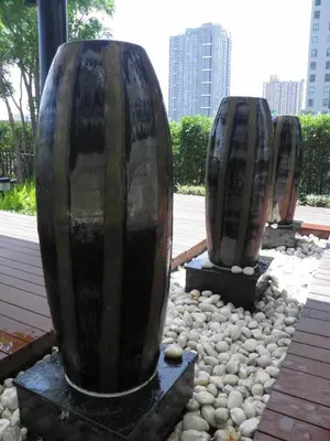 two large vases sitting on rocks in a park at The SkyHouse Duplex - Luxury Home in Bangkok