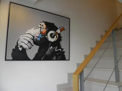 a painting of a man talking on a phone on a wall at The SkyHouse Duplex - Luxury Home in Bangkok