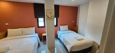 two beds in a room with orange walls at Sleepstation at Pratunam in Bangkok