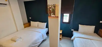 two beds in a small room with blue walls at Sleepstation at Pratunam in Bangkok