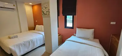 two beds in a room with orange walls at Sleepstation at Pratunam in Bangkok